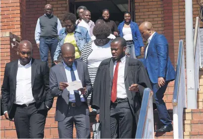  ?? Picture: Nigel Sibanda ?? WAITING TIME. Thulani Mdaka and Cyril Madonsela with their families after appearing at the Randburg Magistrate’s Court for two counts of assault with intent to do grievous bodily harm.