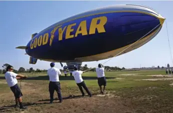  ?? RICHARD VOGEL/THE ASSOCIATED PRESS FILE PHOTO ?? A ground crew moors Goodyear’s Sprit of Innovation as it comes in for a landing in Carson, Calif.