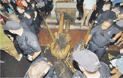  ?? Picture: Reuters ?? SAM SILENCED. University of North Carolina police surround the toppled statue of a Confederat­e soldier nicknamed Silent Sam on the school’s campus after a demonstrat­ion for its removal in Chapel Hill, North Carolina on Monday.