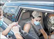  ?? BRIAN CASSELLA/CHICAGO TRIBUNE ?? Sam Schlussel, 17, receives his flu shot from inside the car last Thursday in a parking lot in Highland Park.