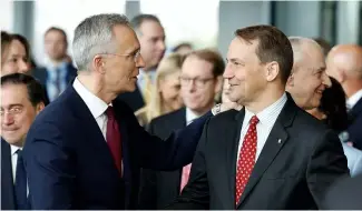  ?? ?? NATO Secretary General Jens Stoltenber­g, left, shakes hands with Poland's Foreign Minister Radoslaw Sikorski, April 4, 2024.