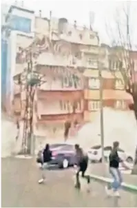  ?? ?? GONE IN SECONDS: Bystanders in the southern Turkish district of Haliliye run for their lives Monday as an apartment tower weakened by Sunday’s earthquake collapses.