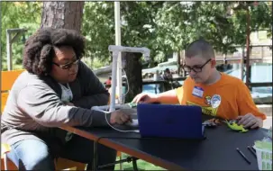  ?? The Sentinel-Record/Rebekah Hedges ?? STOP MOTION: Ashley Smith, left, digital media specialist with the Arts and Science Center for Southeast Arkansas, teaches Randall Kish, of Malvern, how to use stop motion animation Friday during Education in Motion at Magic Springs Theme & Water Park.