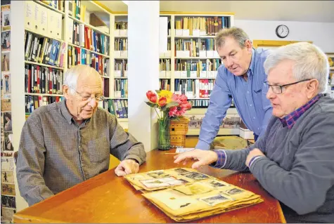  ?? COLIN CHISHOLM ?? From left, John Wilson, past president of the West Hants Historical Society, filmmaker Timothy Reed, and Bob Dimock pour over historical documents for a documentar­y on the region’s history.