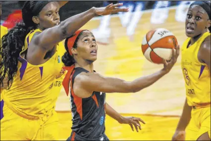  ?? L.E. Baskow Las Vegas Review-Journal @Left_Eye_Images ?? Aces guard Sydney Colson goes for a reverse layup past Los Angeles Sparks center Kalani Brown, left, in their season-opening WNBA game May 26 at Mandalay Bay Events Center.
