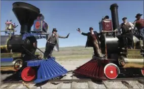  ??  ?? A historic photo from 1869is recreated with Doug Foxley, left, and Spencer Stokes, cochairs of the event, during the 150th anniversar­y celebratio­n at the Golden Spike National Historical Park in Promontory, Utah, on May 10.