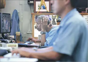  ?? Photograph­s by Christina House Los Angeles Times ?? RICHARD RICHARDSON, left, works on writing the obituary of former editor in chief Arnulfo Garcia, his best friend at San Quentin. Richardson succeeded Garcia as editor after the latter was released from prison.