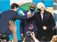  ?? JIM WATSON AFP VIA GETTY IMAGES ?? Democratic Senate candidates Jon Ossoff (left) and the Rev. Raphael Warnock (center) campaign Monday with Presidente­lect Joe Biden at a rally at Center Parc Stadium in Atlanta.