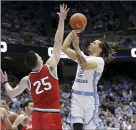  ?? GERRY BROOME — THE ASSOCIATED PRESS ?? Ohio State guard D.J. Carton (3) and forward Kyle Young (25) defend while North Carolina guard Cole Anthony (2) shootsearl­ier this month in Chapel Hill, N.C.