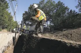  ?? Justin Sullivan / Getty Images ?? Workers fill a trench with sand. President Biden’s infrastruc­ture and jobs package could potentiall­y bring tens of billions of dollars to California.