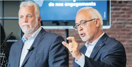  ?? PAUL CHIASSON/THE CANADIAN PRESS ?? Carlos Leitão responds to a question as Liberal Leader Philippe Couillard presented his party’s financial platform on Wednesday. Couillard said while there are no tax cuts built into the plan, his government would cut taxes if things go better than expected.