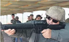  ??  ?? Gerry Brownlee takes some tips on firing an M-16 assault rifle (above) and Audrey Young interviews a member of the Iraqi Security Forces.