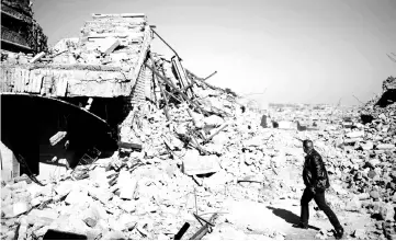  ?? — Reuters photo ?? File photo shows an Iraqi man walking past a destroyed tomb of the Prophet Jonah (Nabi Younes) in the eastern side of Mosul, Iraq.