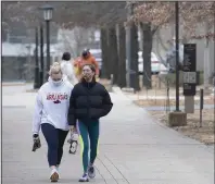  ?? (NWA Democrat-Gazette/J.T. Wampler) ?? Erin Enmark (left) and Peyton Mosman walk back to their sorority house after going to the gym Monday on the University of Arkansas, Fayettevil­le campus. Monday was the first day of classes after the holiday break.