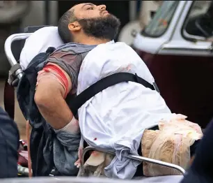  ??  ?? Wounds: Bearded Rahami is taken to hospital with gunshot injuries