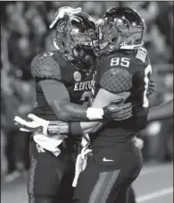 ?? AP/DAVID STEPHENSON ?? Kentucky running back Jojo Kemp (left) is congratula­ted by tight end Steven Borden after Kemp’s touchdown during the Wildcats’ victory over South Carolina on Saturday night.