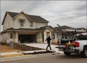  ?? (Bloomberg News WPNS/Jordan Vonderhaar) ?? A worker walks in front of a house under constructi­on in Kyle, Texas in March.