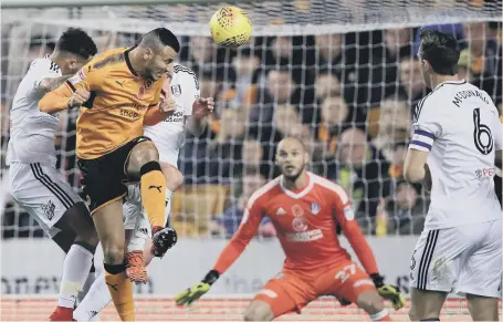  ??  ?? Romain Saiss rises to head home Wolves’ opener in last night’s Championsh­ip win over Fulham.