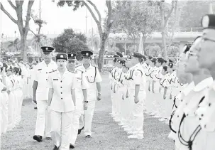  ??  ?? PERIKSA: Dr Chan melakukan pemeriksaa­n kontinjen perbarisan ditemani Selvaraj (kiri) pada Perbarisan Tahunan 2018 Hari Palang Merah Sedunia di Miri, semalam.