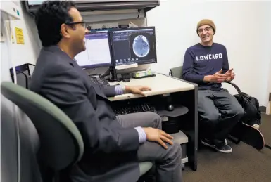  ?? Photos by Scott Strazzante / The Chronicle ?? Sean Sanford (right), who fell off his skateboard and had a concussion, chats with Dr. Manu Hegde at UCSF.