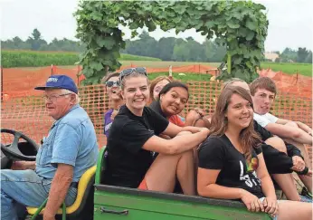  ?? COURTESY OF ALTENBURG'S FARM ?? Harold Altenburg drives students in a tractor at Altenburg's Farm.