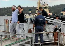  ?? FAIRFAX ?? Men are escorted by police off the Carnival Eden cruise ship in Eden, New South Wales after fighting that forced the cruise to be cut short.