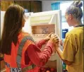  ?? MARY HUBER / BASTROP ADVERTISER ?? Bastrop High students stock a fridge in the student council classroom for Bears Who Care, which helps feed students in need.