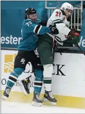  ?? TONY AVELAR — THE ASSOCIATED PRESS ?? Minnesota Wild defenseman Carson Soucy (21) is checked into the boards by San Jose Sharks center Noah Gregor (73) during the first period in San Jose on Monday.