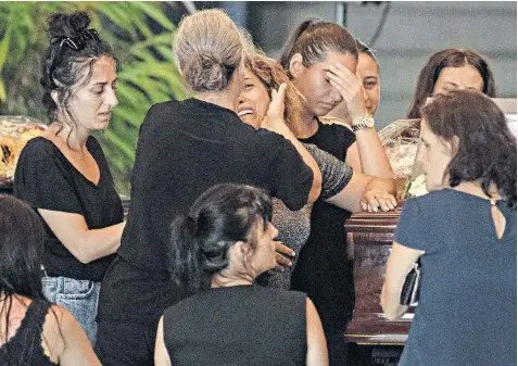  ??  ?? Weeping relatives pay their respects at the coffin of one of the victims of the bridge collapse