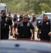  ?? AP FILE ?? Police walk near Robb Elementary School following a shooting, Tuesday, in Uvalde, Texas.