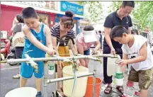  ?? Below: ZHU XIANG / XINHUA ?? in Zhengzhou as the city gets back on track after heavy flooding. People get water at a temporary water supply station on Thursday