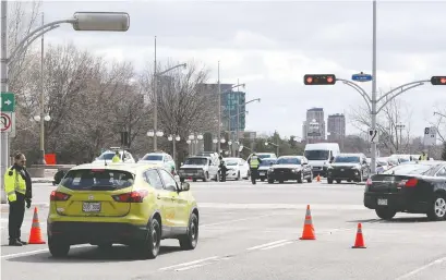  ?? JEAN LEVAC ?? Gatineau police officers control traffic to and from Gatineau this week on the Portage Bridge.