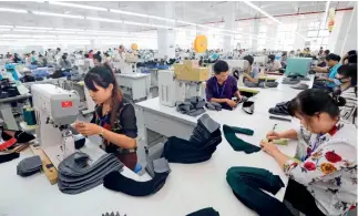  ?? Fotos de Cnsphoto ?? 13 de septiembre de 2018. Una línea de fabricació­n de calzados en Chongzuo (Guangxi), ciudad experiment­al de la cooperació­n China-Vietnam.