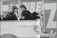  ?? AP/South Florida Sun-Sentinel/JOHN McCALL ?? Law enforcemen­t officials tend to a wounded person Wednesday in the back of a pickup outside the high school in Parkland, Fla.