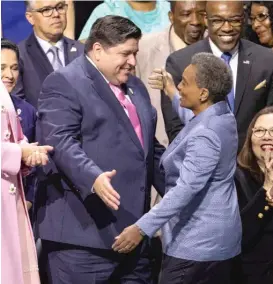  ?? SUN-TIMES FILES ?? Lori Lightfoot greets Gov. J.B. Pritzker before she was sworn in as Chicago mayor last May at Wintrust Arena.