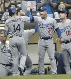  ?? Morry Gash Associated Press ?? ENRIQUE HERNANDEZ IS greeted by manager Dave Roberts after his three-run homer in the top of the ninth inning gave the Dodgers a 6-2 lead.