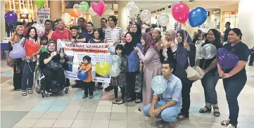  ??  ?? Norfariza with Ting (fourth left), Leong (seventh right), relatives and friends at the Miri Airport on Monday.