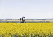  ?? TODD KOROL • REUTERS ?? Canola fields surround an oil pump jack in rural Alberta.