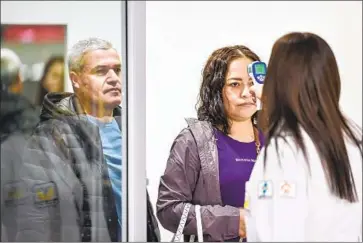  ?? Pedro Pardo AFP/Getty Images ?? A PASSENGER gets her temperatur­e taken last week at Benito Juarez Internatio­nal Airport in Mexico City.