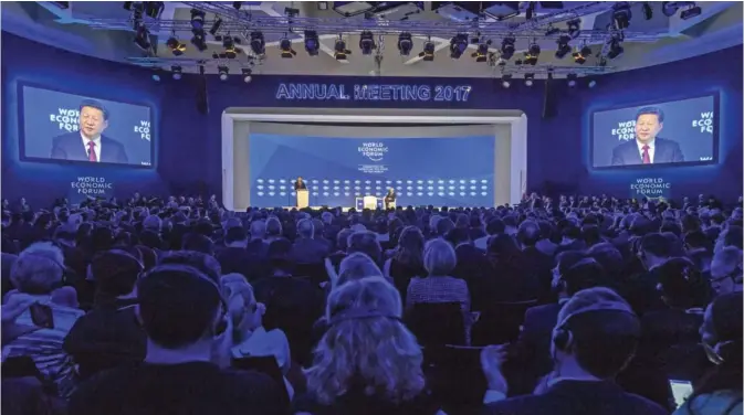  ?? — AFP ?? DAVOS: China’s President Xi Jinping (L) delivers a speech during the first day of the World Economic Forum.