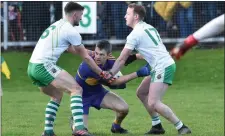  ??  ?? Jason Browne, St. Senans, is tackled by Micheál Foley and Padraig Enright, Ballydonog­hue, in the North Kerry SFC final