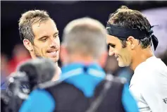  ?? — AFP photo ?? France's Richard Gasquet (L) talks to Switzerlan­d's Roger Federer after their men's singles third round match on day six of the Australian Open tennis tournament in Melbourne on January 20, 2018.