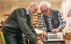  ??  ?? Das Repair-Café in der Beratungss­telle der Verbrauche­rzentrale. Reinhard Keller repariert den Toaster von Klaus Kurtz (l.).