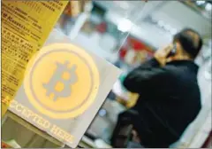  ?? PHILIPPE LOPEZ/AFP ?? A man in a shop displaying a bitcoin sign during the opening ceremony of the first bitcoin retail shop in Hong Kong in 2014.