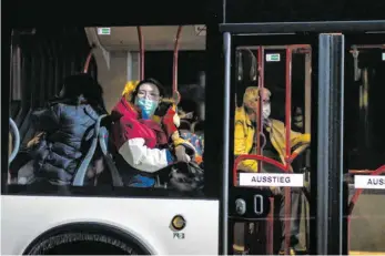  ?? FOTO: FRANK RUMPENHORS­T/DPA ?? Ein Bus mit wegen des Coronaviru­s evakuierte­n Menschen kommt in der Nacht in einem Konvoi an der Kaserne Südpfalz der Bundeswehr an. Die Menschen tragen Atemschutz­masken.