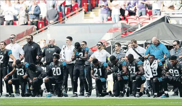 ?? PAUL CHILDS / REUTERS ?? Los jugadores de los Jacksonvil­le Jaguars ponen la rodilla en tierra al sonar el himno de EE.UU. antes del partido