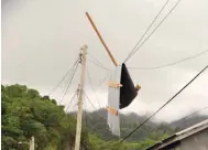  ??  ?? Debris hangs from utility lines in Sandy Bay, St. Vincent and the Grenadines, following the passing of Hurricane Elsa in an area on the north coast.