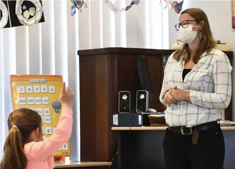  ?? AFP ?? A teacher at Olfa Elsdonk primary school in Belgium gives a lesson while wearing a face mask this month, with schools across the world gradually reopening, albeit with measures in place to protect staff and pupils from the spread of Covid-19