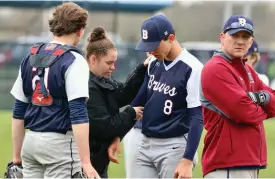  ?? ?? Bellmont head coach Tom Montgomery (right) was forced to alter his game plan early after his starter, Eli Laurent (center), was forced to leave the game due to injury. Shown being examined by the Norwell trainer, Laurent, the team’s leading hitter with a .429 average, was hit by a pitch in the top of the inning and only faced three batters before calling for the trainers.