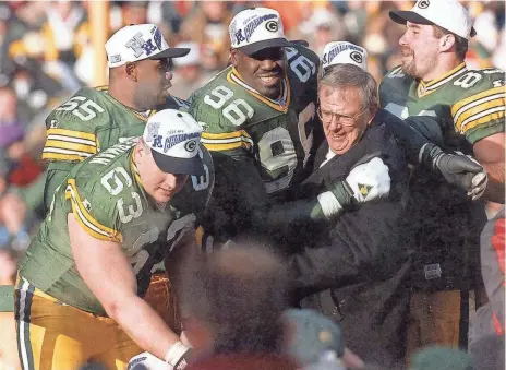  ?? PACKER PLUS FILES ?? Then-Packers general manager Ron Wolf gets a hug from Sean Jones after Green Bay won the NFC Championsh­ip Game against the Carolina Panthers on Jan. 12, 1997.